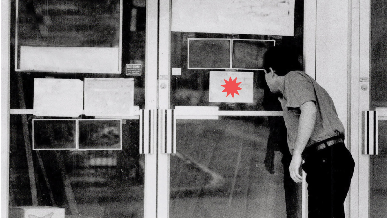 a man peering at advertisements in a shop window